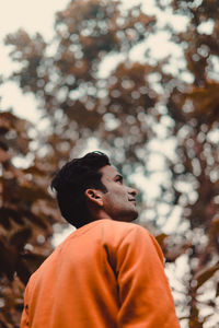 Low angle view of man standing against trees