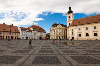 People on town square against buildings in city