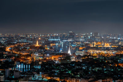 High angle view of illuminated cityscape against sky at night