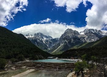 Scenic view of lake by mountains against sky