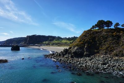 Pristine, blue water lays at rest on the rocky shoreline of the southern oregon coast.