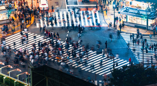 Blurred motion of people crossing road on city