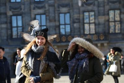 Young women wearing warm clothing walking in city