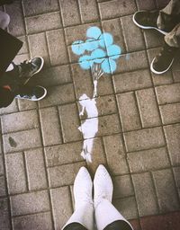 Low section of people standing by graffiti on footpath