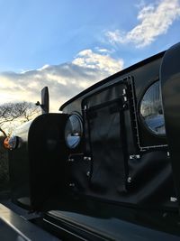 Cars on road against cloudy sky