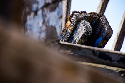 Close-up of rusty metal on wood against wall