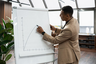 Side view of young man standing in office