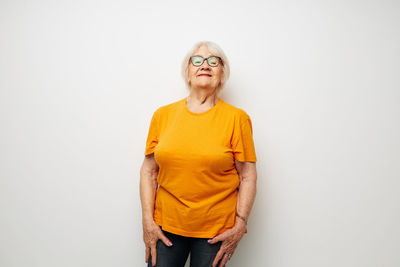 Portrait of young woman standing against white background