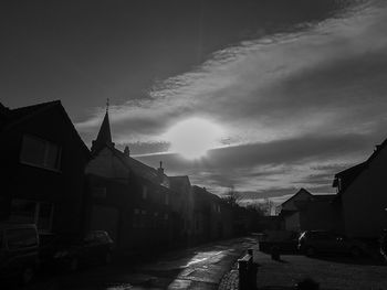 Street amidst houses in town against sky