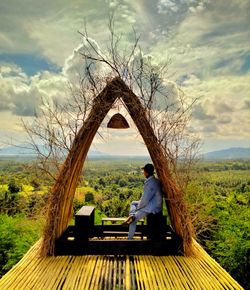 Rear view of man sitting on bench