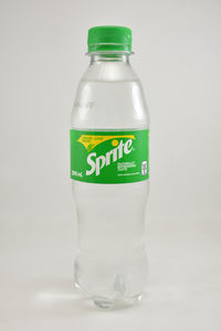 Close-up of empty glass bottle against white background