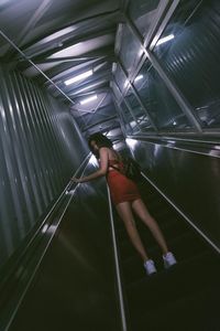 Low angle view of woman standing on escalator