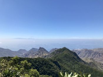 Scenic view of mountains against blue sky