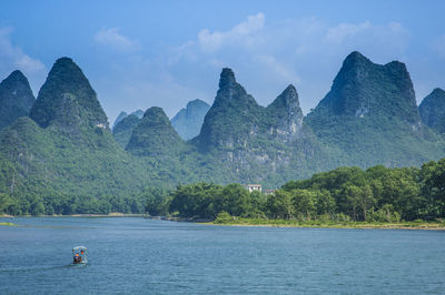 Scenic view of river and mountains against sky