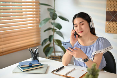 Young woman using mobile phone at office