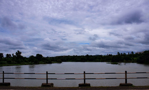 Scenic view of calm lake against cloudy sky