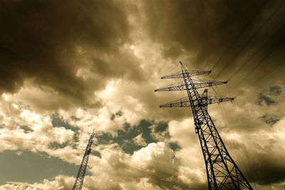 Low angle view of communications tower against cloudy sky