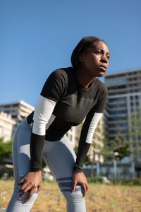 Tired african american runner resting on street