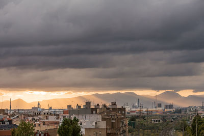 Buildings in city against sky during sunset