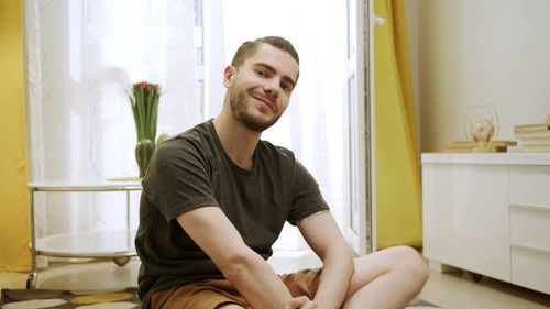 Portrait of young man sitting at home