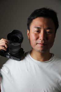 Portrait of young man holding camera