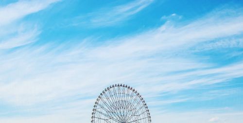 Cropped image of ferris wheel against sky