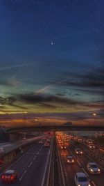 Road passing through illuminated tunnel at night