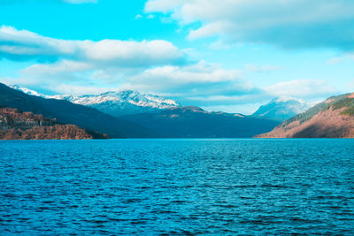 Scenic view of sea and mountains against sky