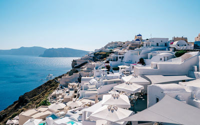 High angle view of townscape by sea against clear sky