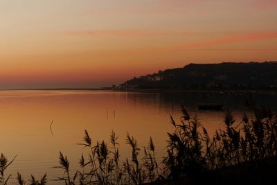 Scenic view of calm sea against orange sky