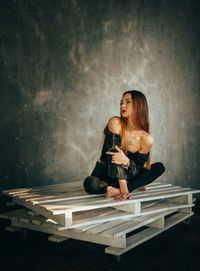 Full length of woman sitting on floor