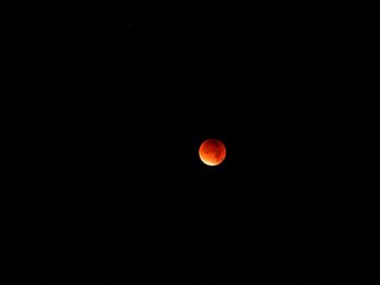 Red moon against clear sky at night