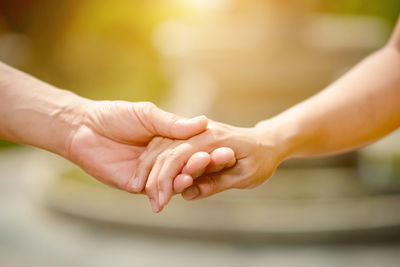 Midsection of couple holding hands