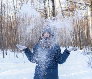 Woman standing on snow covered land during winter