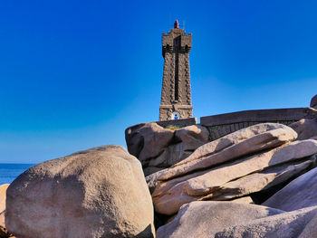 Low angle view of lighthouse against clear blue sky