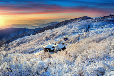 Scenic view of snowcapped mountains against sky during sunset