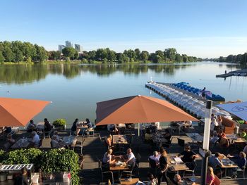 People on lake against clear sky