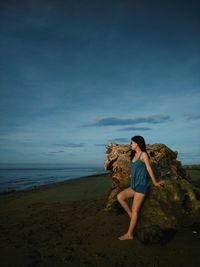 Full length of woman standing at beach against sky