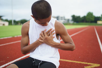 Rear view of man exercising on field