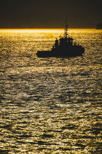 Silhouette boat in sea against sky during sunset