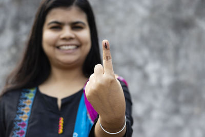 Selective focus on ink-marked finger of an indian woman with smiling face