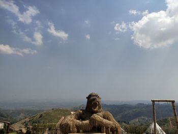 Statue of buddha against cloudy sky