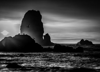 Rock formation on sea against sky