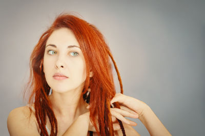 Portrait of beautiful young woman against white background