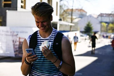 Smiling man using mobile phone