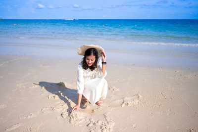 Rear view of woman standing at beach