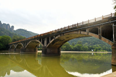 Photo of a traditional chinese style arch bridge on the river