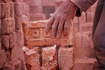 Human hand on stone wall