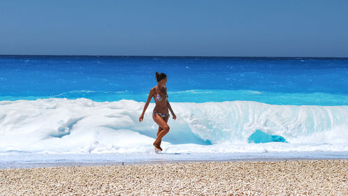 Full length of boy on beach against sky