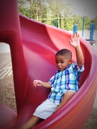 Boy enjoying slide in park